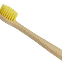 Close up of yellow bristles on a bamboo toothbrush
