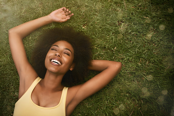 black woman happy laying on grass