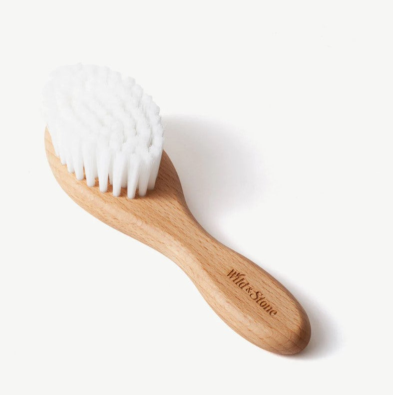 Baby hair brush made from bamboo laying on it's back