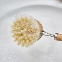 bamboo dish brush with handle covered with soap bubbles 