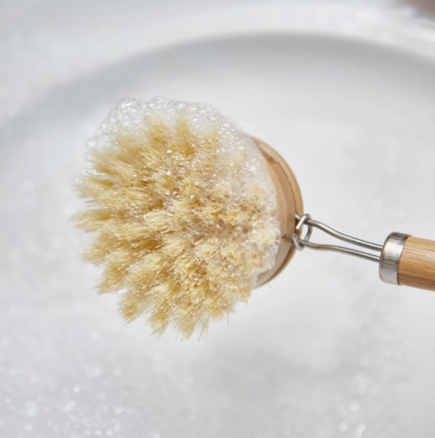 bamboo dish brush with handle covered with soap bubbles 
