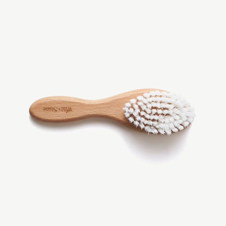 Baby hair brush made from bamboo laying on it's side